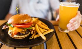 A burger and fries meal paired with a glass of beer