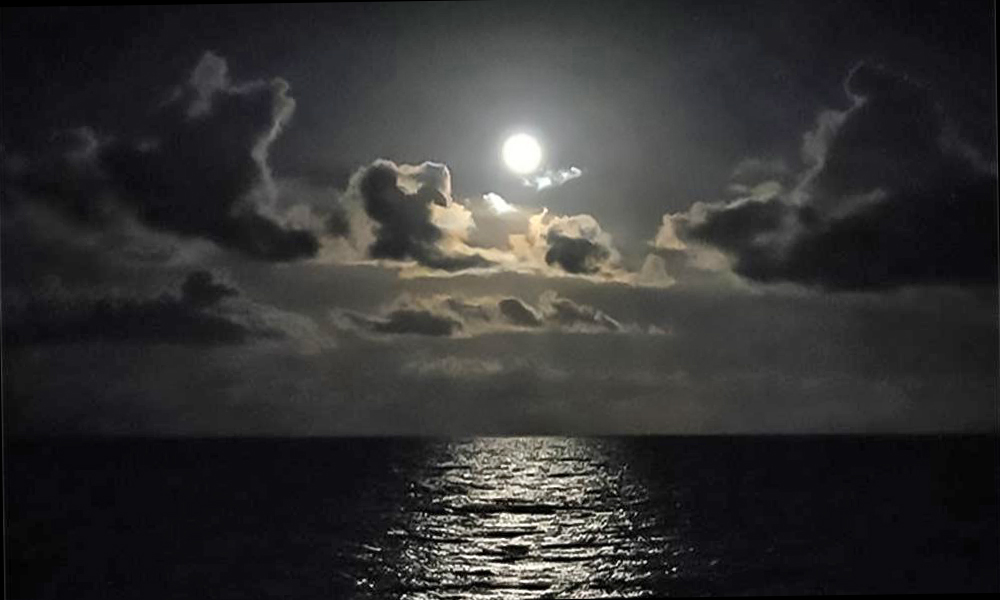 Taken at night from The Reef restaurant in St. Augustine, showing the full moon over the ocean, with clouds between moon and sea