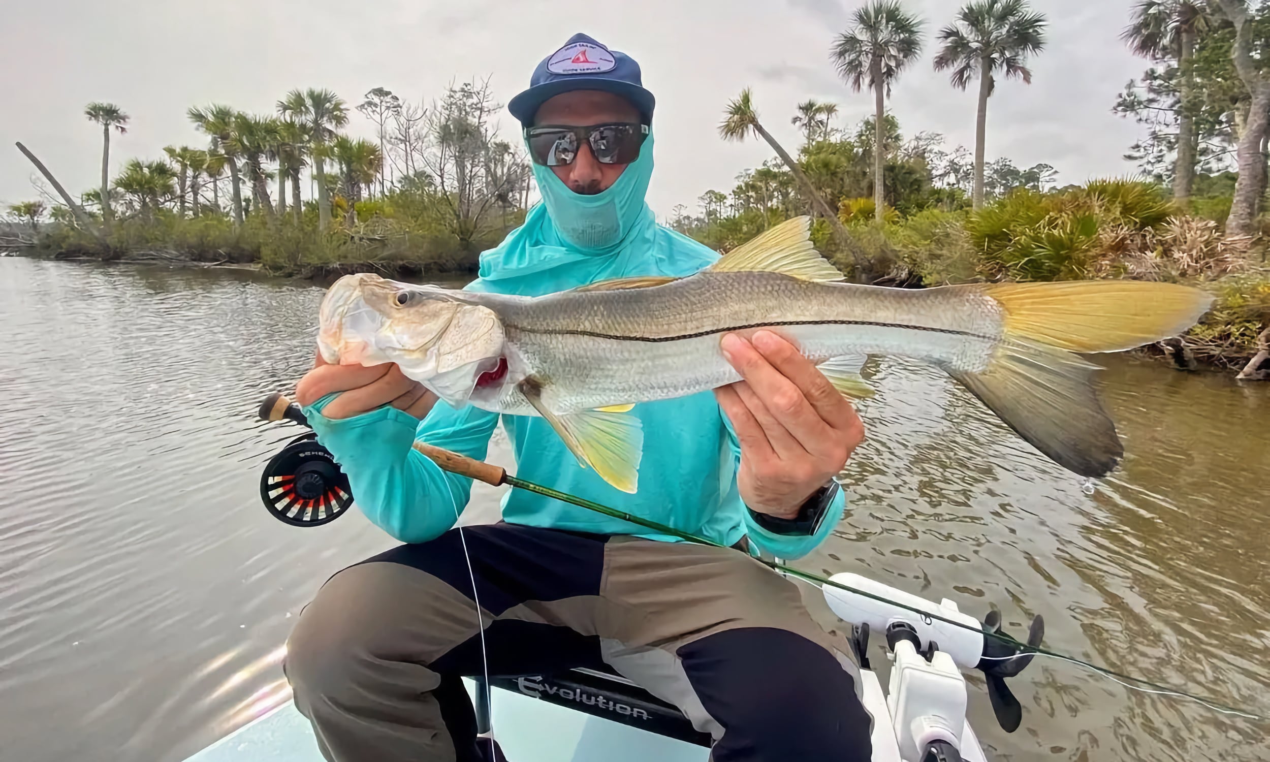 Fisherman holding a snook caught during a trip with High Tailin Charters