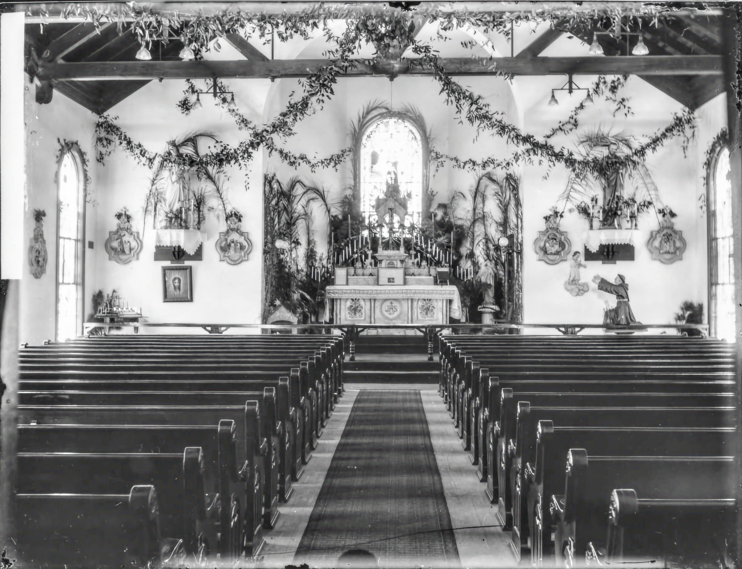 B&W, interior of St. Benedict the Moor Catholic Church in Lincolnville, the altar decorated for Christmas or Palm Sunday.