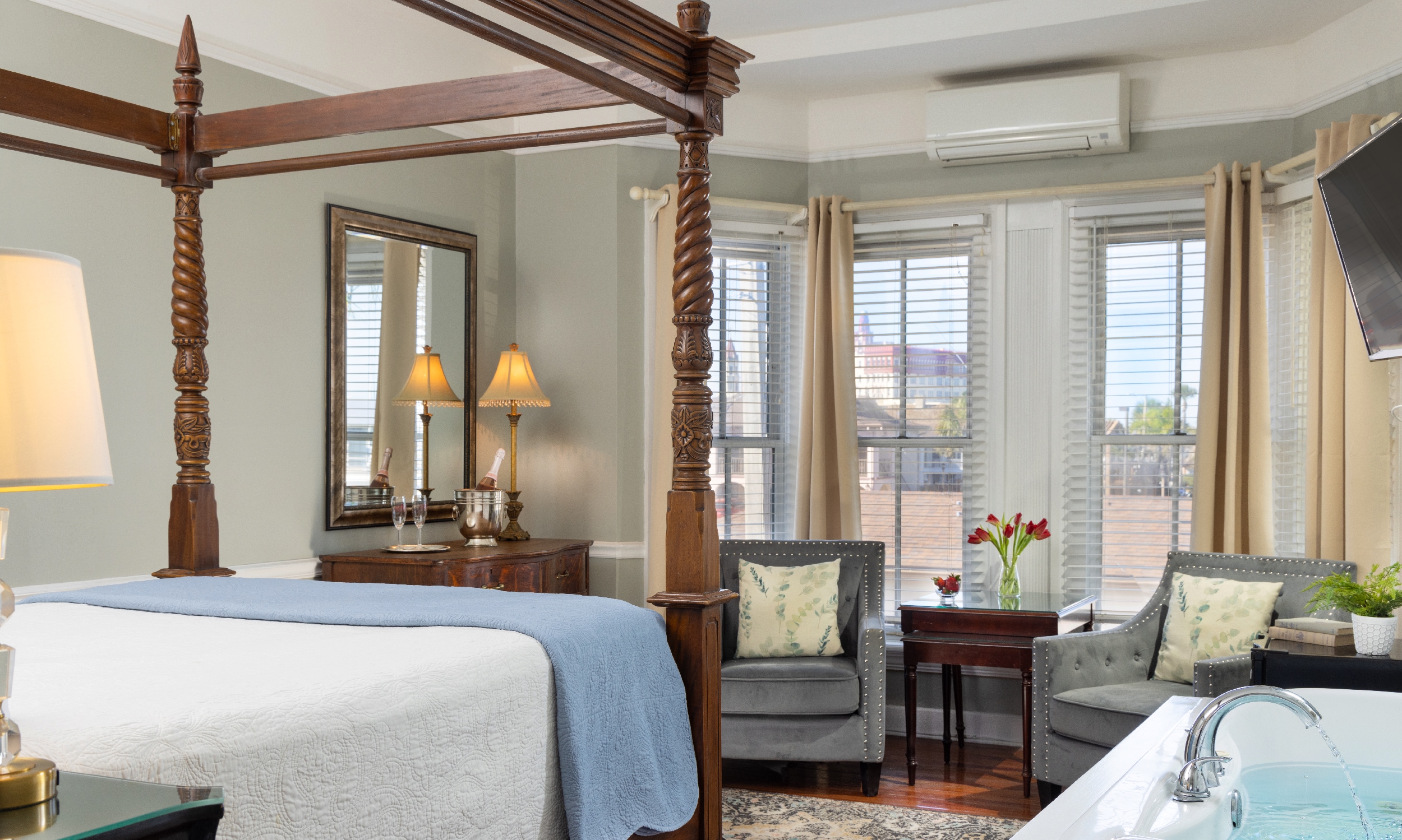 This room in the Bayfront Marin Bed and Breakfast has soft blue decor, a four-poster bed, and a soaking tub