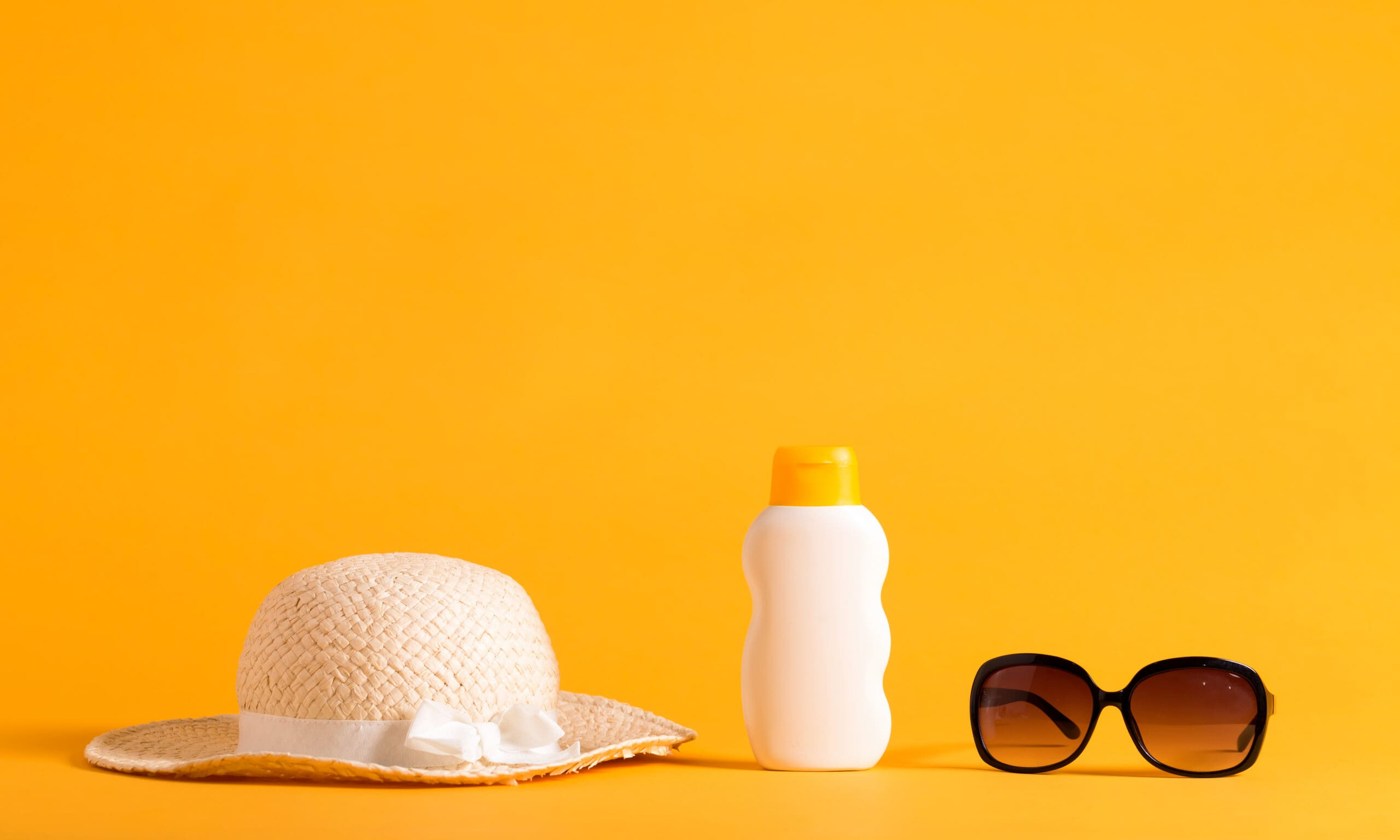 A sun hat with sunscreen and sunglasses