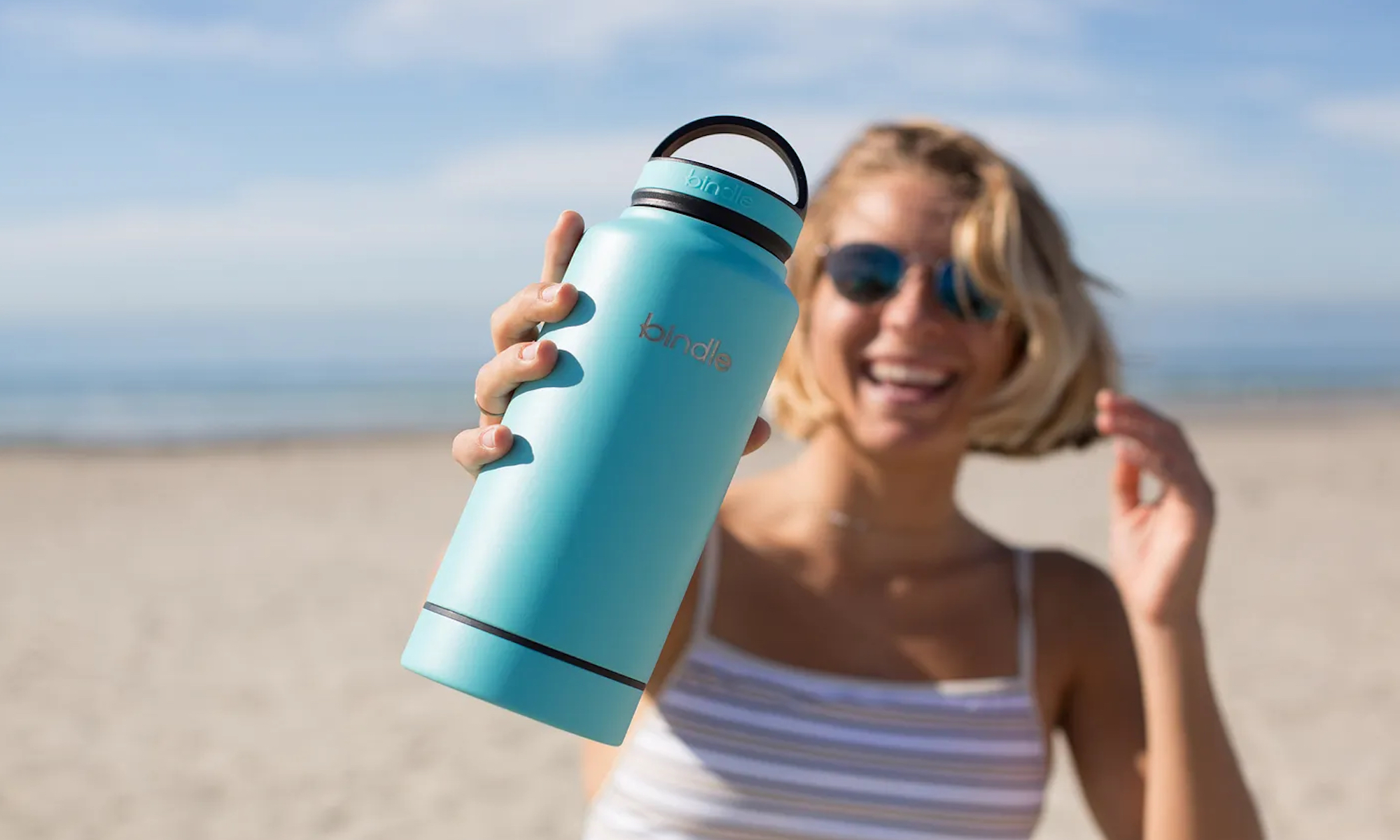 Woman holding water bottle on the beach