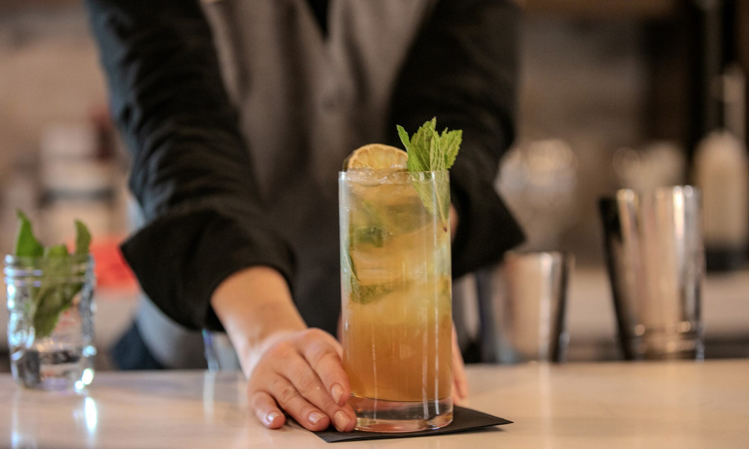 A bartender serves a cocktail