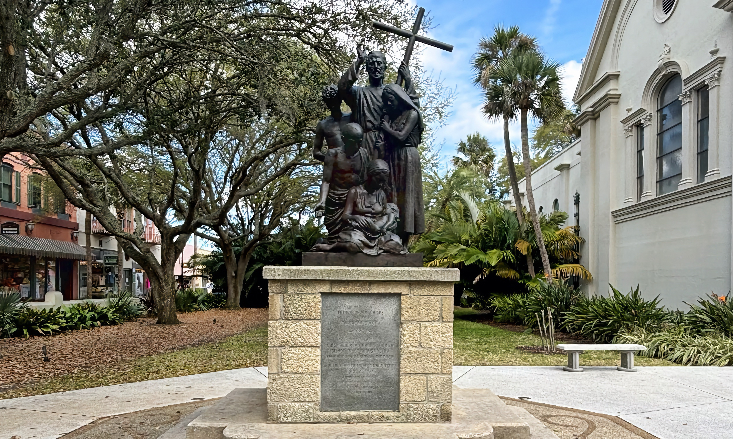 A statue of a priest with a cross.