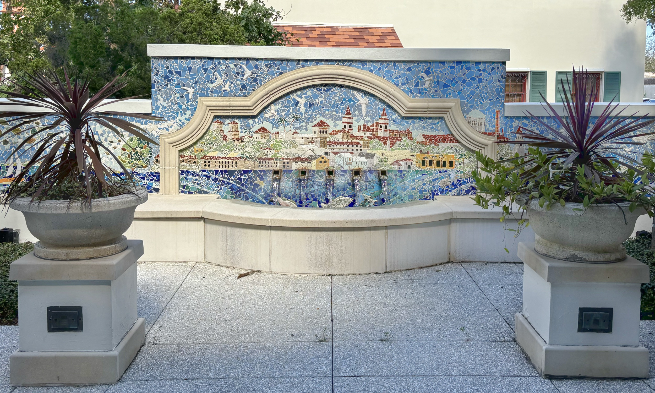 A mosaic behind a fountain