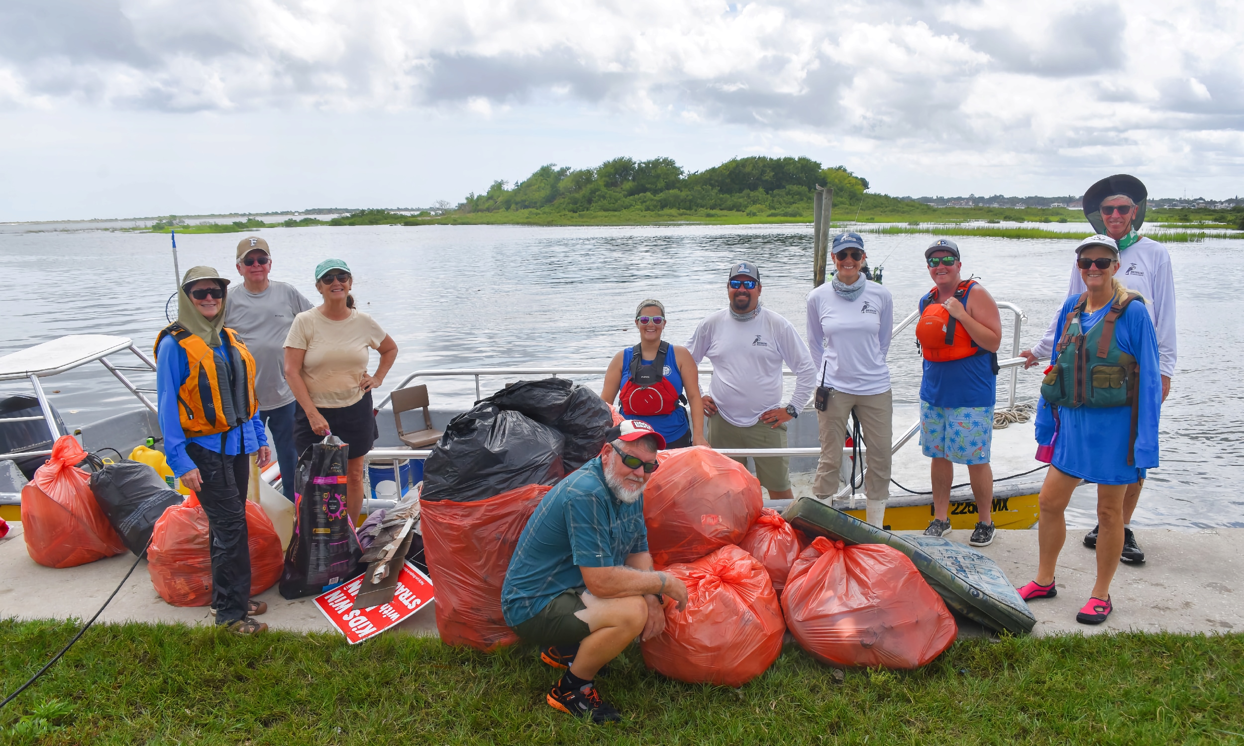 A group of volunteers on the dock with bags of trash gathered from the Matanzas River