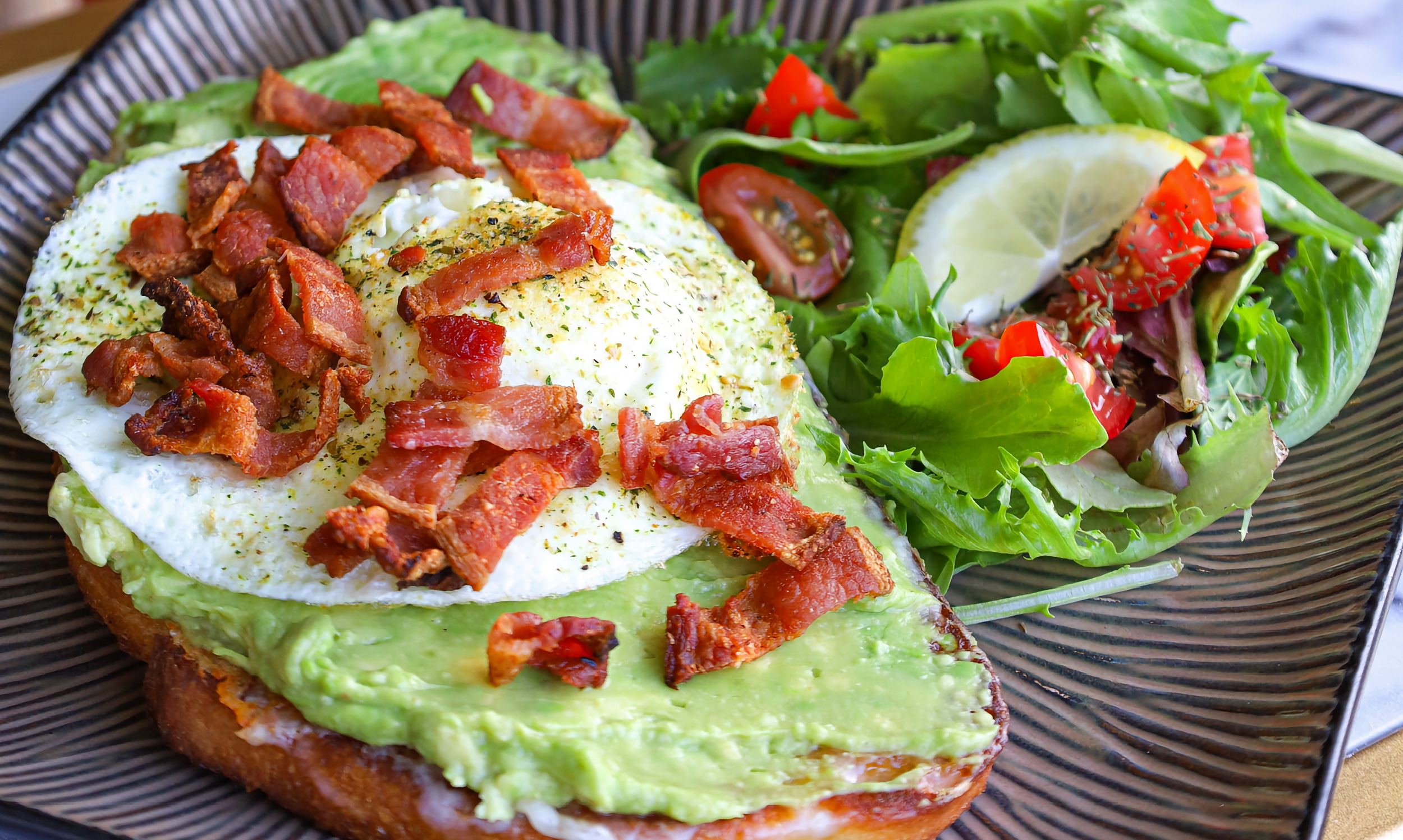 Avocado toast at the Modern Rose, served with an egg (over-easy) and small bites of bacon