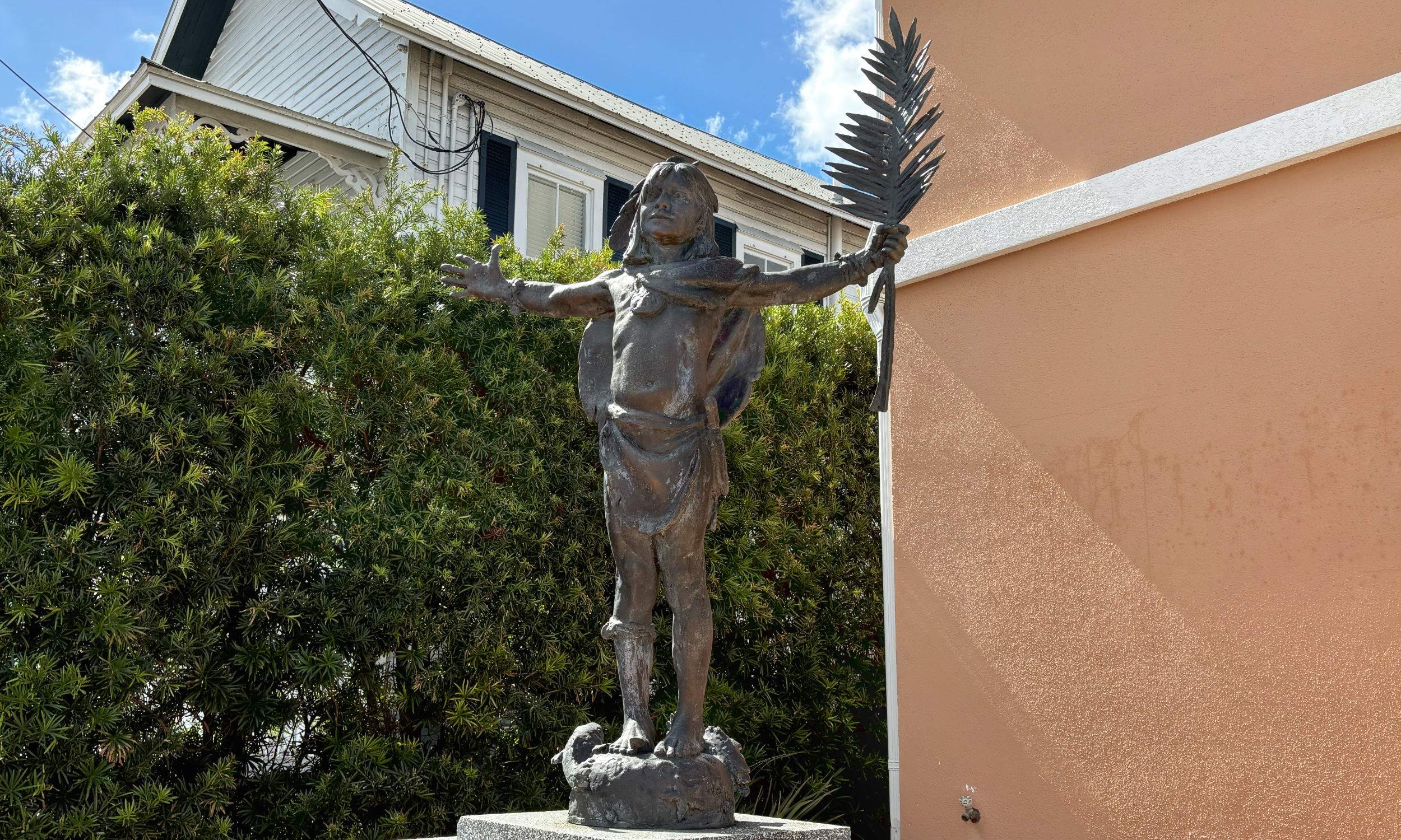 A sculpture of a Native American holding a feather