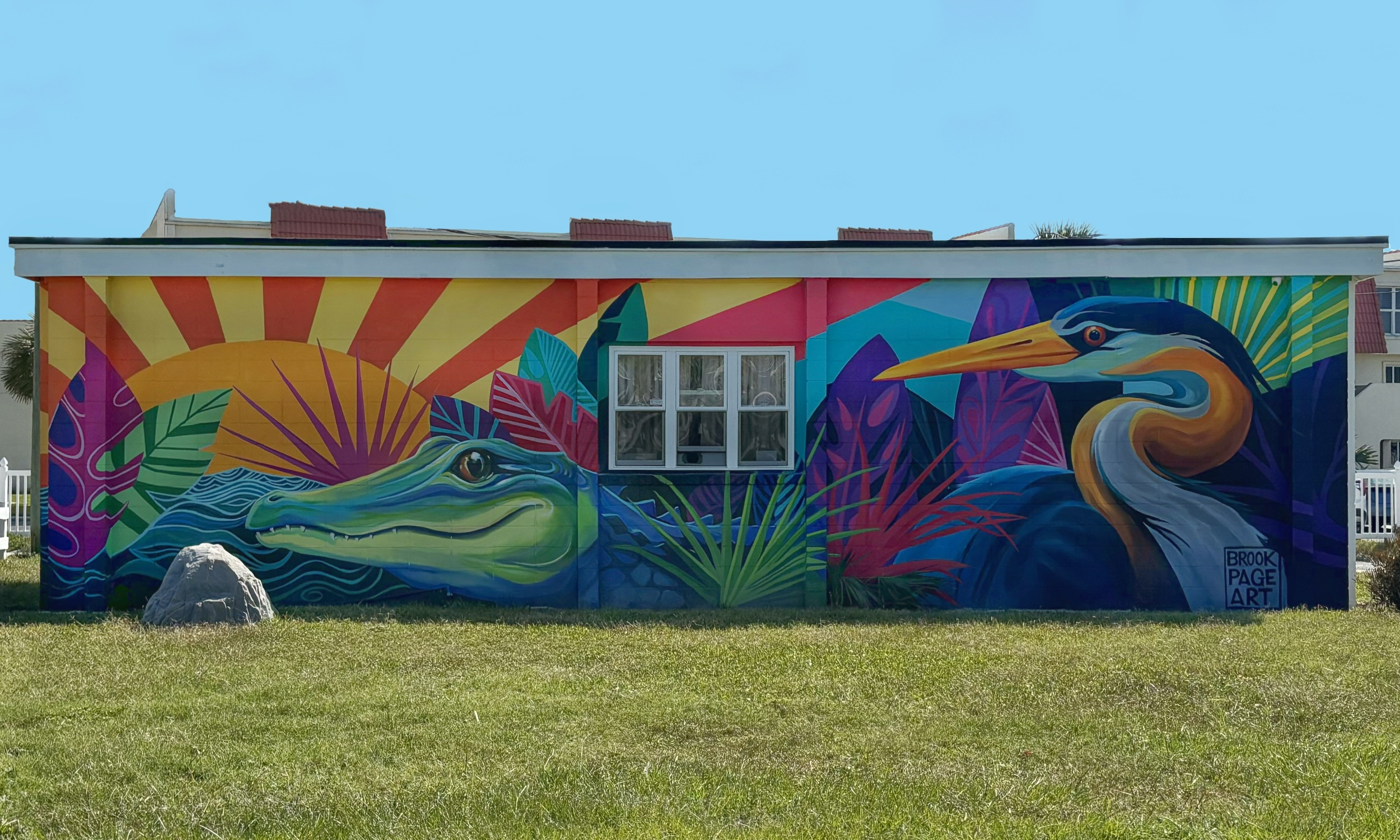 A colorful mural of an alligator and a bird on an outdoor wall