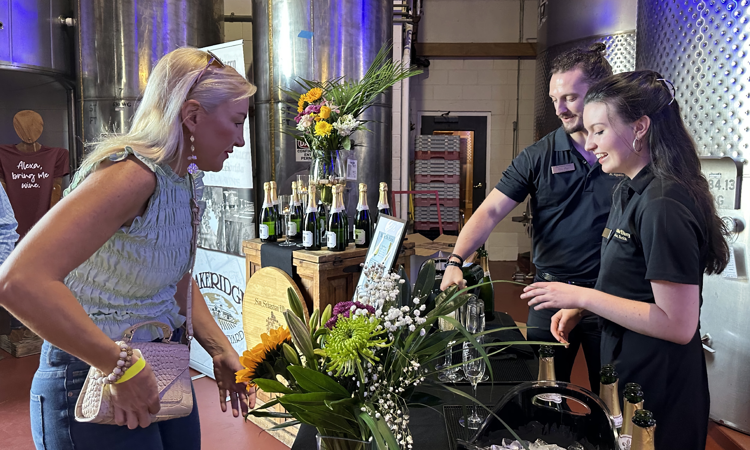 A lady talking with the wine specialists at San Sebastian Winery in St. Augustine