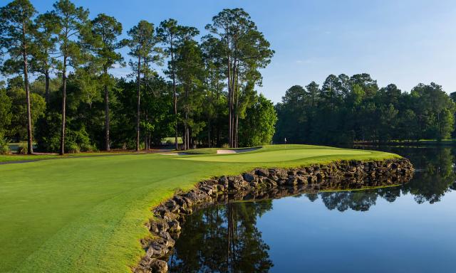 Scenic hole at the King and Bear golf course with waterfront green and forested backdrop