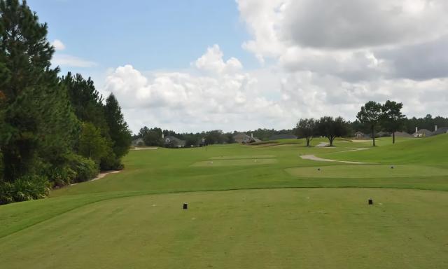 Expansive view from the tee box at the Golf Club at South Hampton with manicured fairways, strategic bunkers, and left-side tree barrier