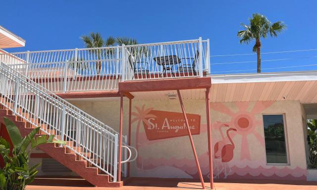 Pink flamingos and welcome to st. augustine mural on the side of a motel