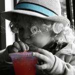 Cute kid in a hat drinking juice at one of St. Augustine's many family-friendly restaurants.