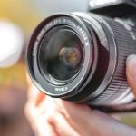 A photographer adjusts his lens to take a picture. 