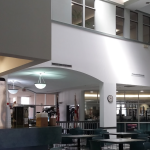 A full color image of the interior of the St. Johns County tax collecotr's office. There are chairs and tables in front of the DMV office windows.