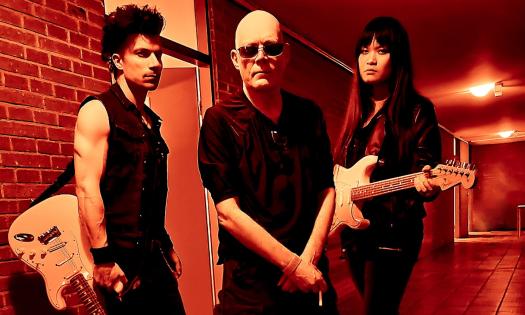 Bandmates from The Sisters of Mercy pose with their guitars. 