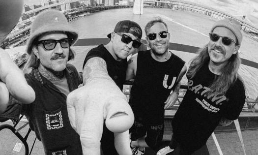 Bandmates from The Used pose in a black and white photo.