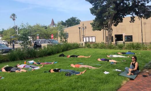 Yoga students laying down in the grass