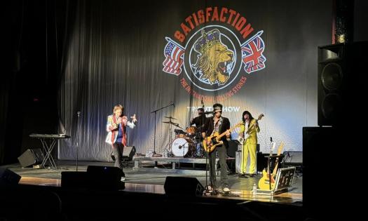 Bandmates from the Rolling Stones Tribute Band perform on stage.