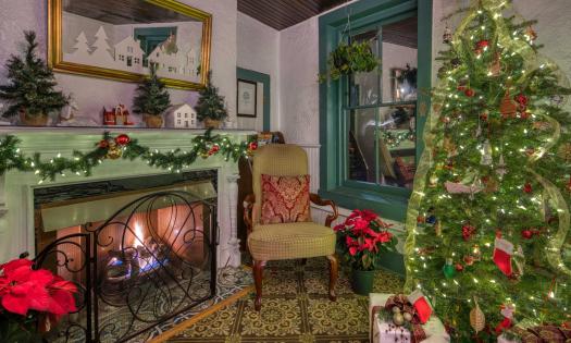 The common room in a local bed and breakfast inn, with a Christmas tree and green adn red decorations