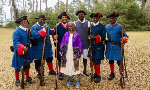 A group of reenactors standing on the old battleground of Fort Mose in the autumn