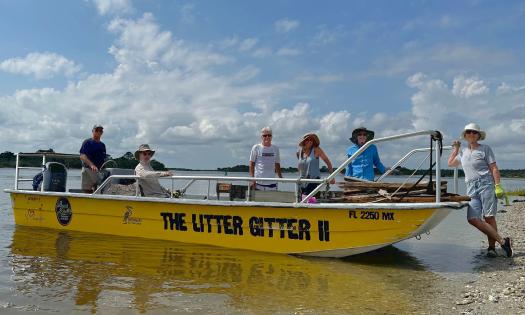 The Matanzas Riverkeeper's trash collection boat, pulled up to the beach with volunteers 