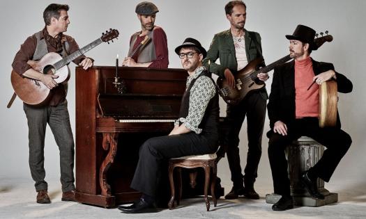 The bandmates of Doolin' pose with their musical instruments against a white backdrop.