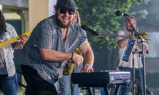 Victor Wainwright smiles and plays the keyboard for fans.