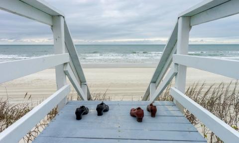 Shoes placed on a boardwalk at the beach