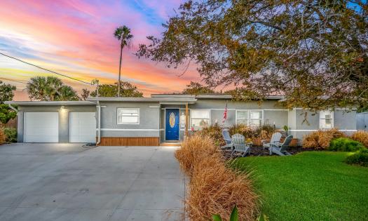 The view of Adventure Oasis vacation rental from the street with a red-streaked sky