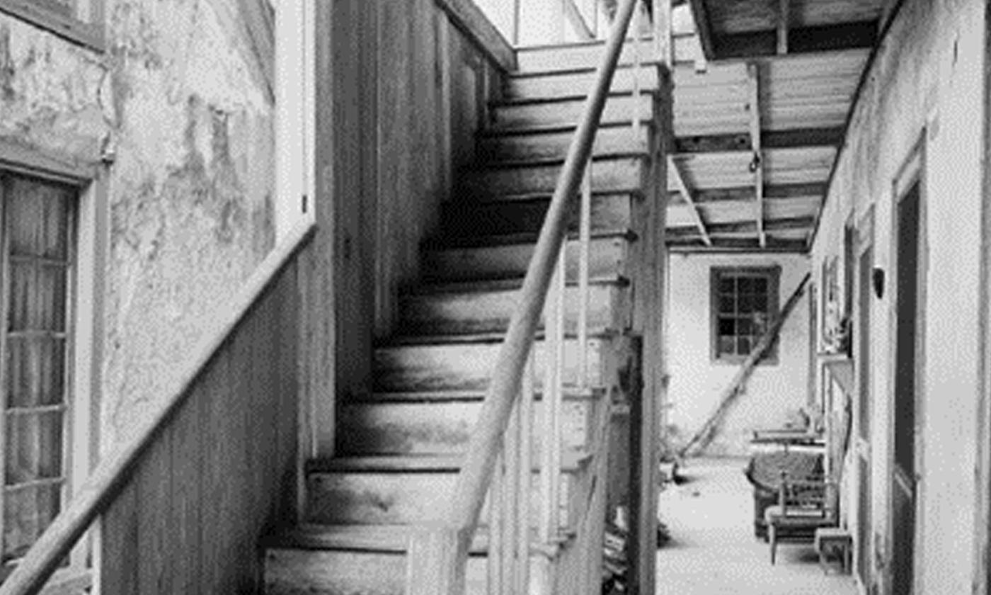 Black and white photo of spooky old stairs in an historic building