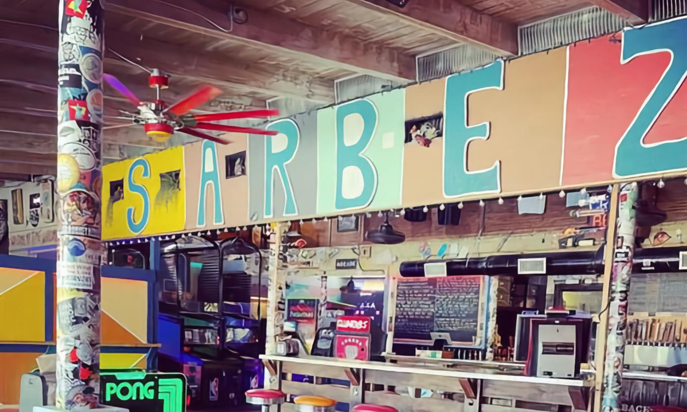 The interior of Sarbez with a small bar and stools and bright paint