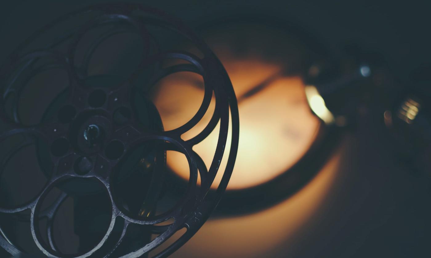 A film reel turns under a small light. 