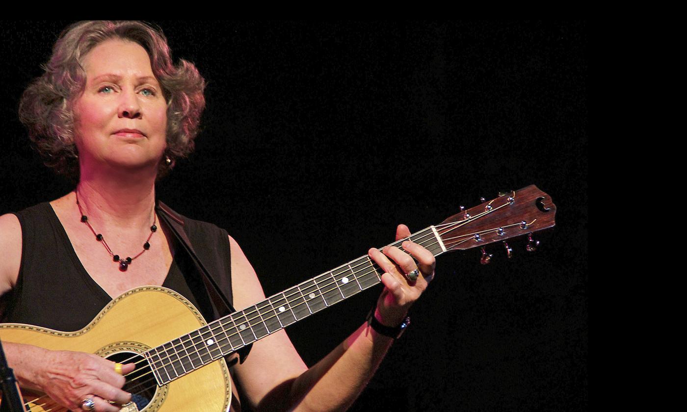 Mary Flower performing on a dark stage