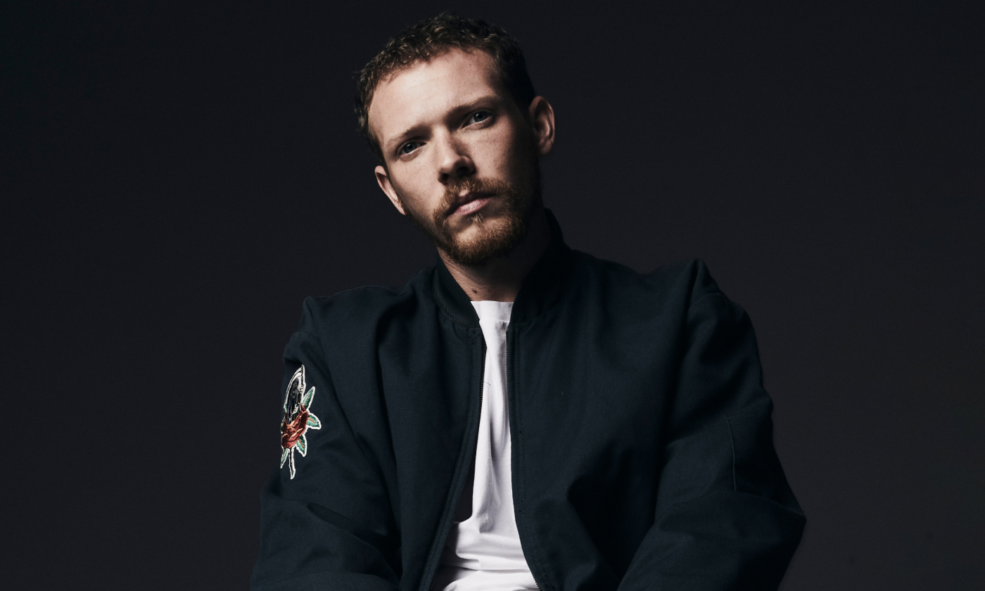 Matt Maeson poses in front of a black background. 