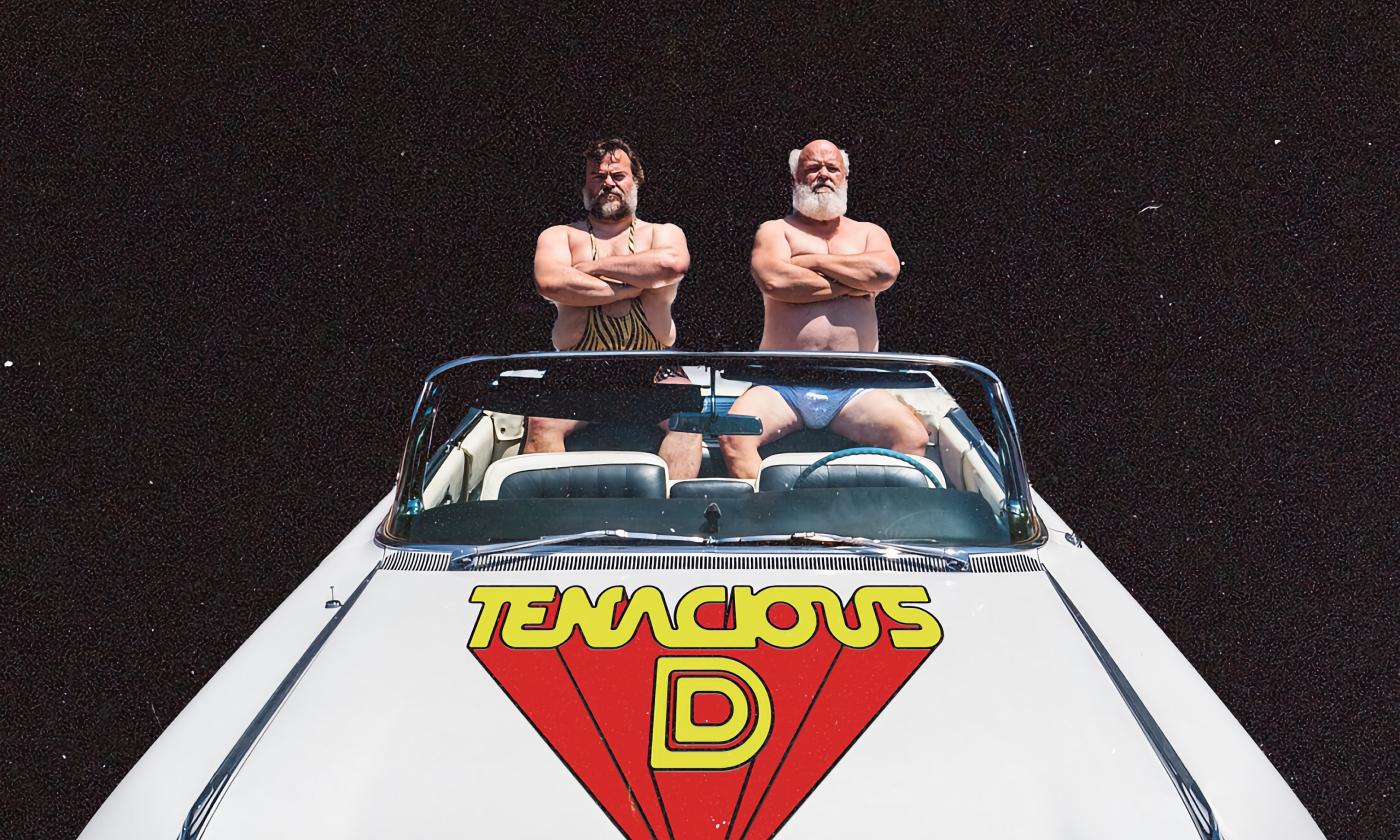 Jack Black and Kyle Gass in swimsuits sitting in the back of a white convertible