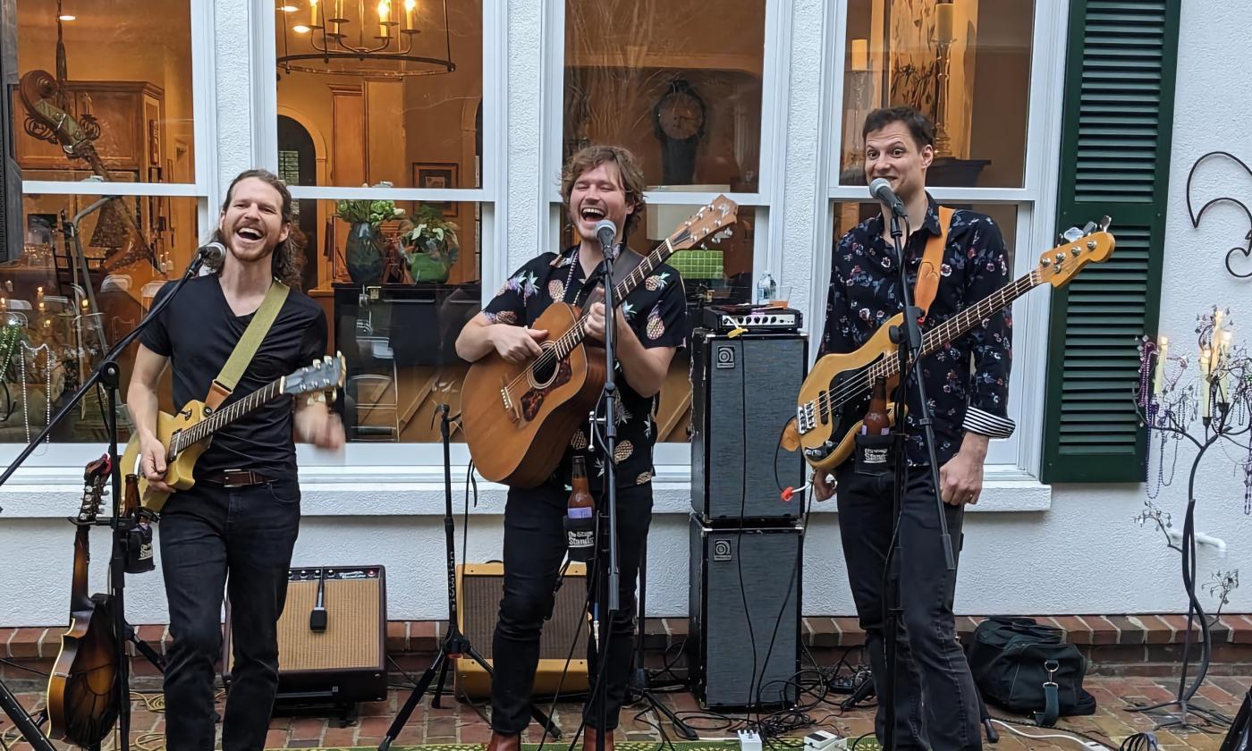 The Currys, a band of three musicians, performing on an outdoor stage