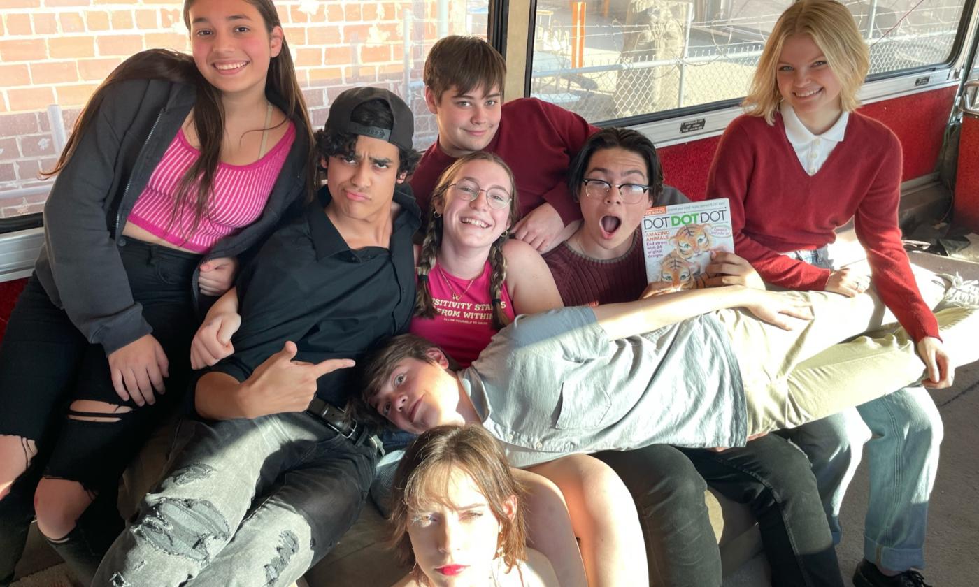 Student actors from APEX Studios grouped together on a bus