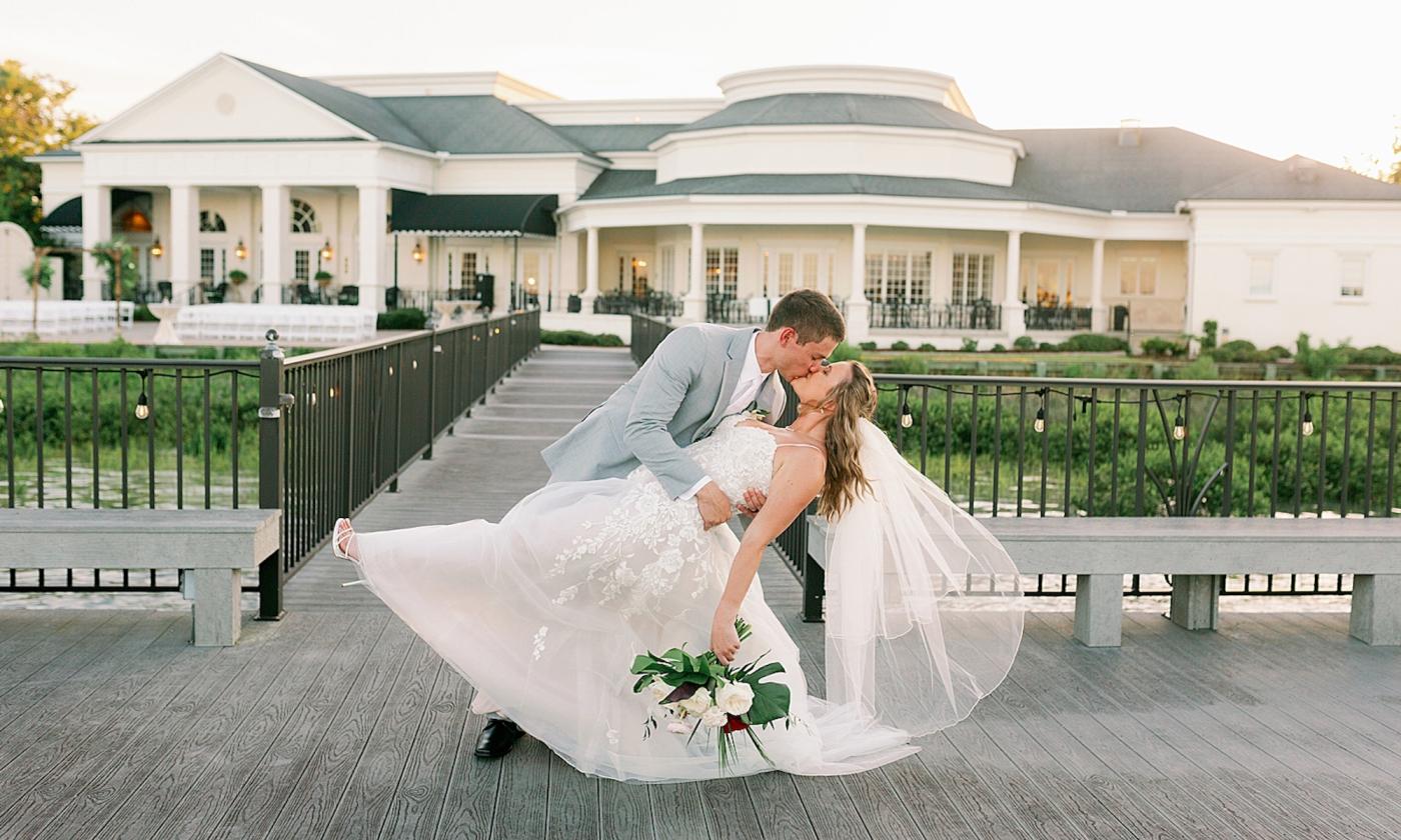 A wedding couple kisses outside the River House