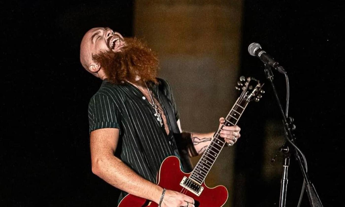 Dyer Davis, with head thrown back, playing his electric guitar and singing