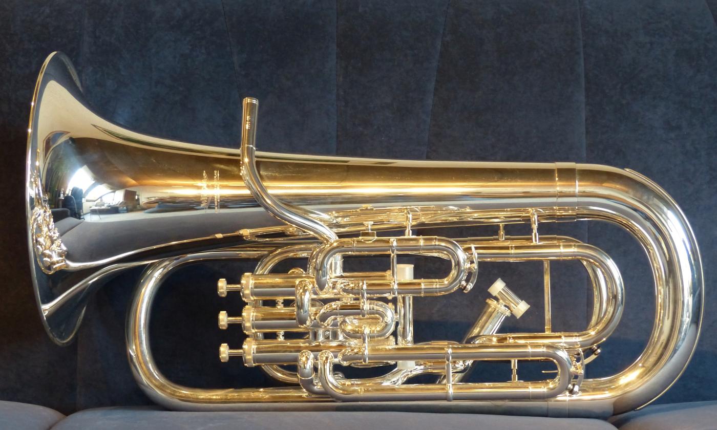 A euphonium on a blue plush bench, prior to a concert