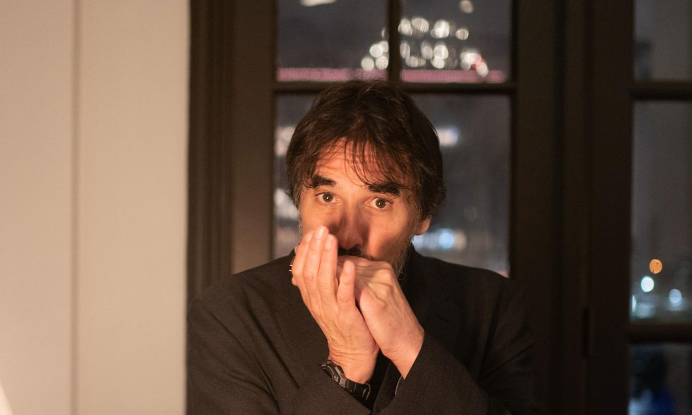 Singer-songwriter Spook Handy playing harmonica, looking directly into camera