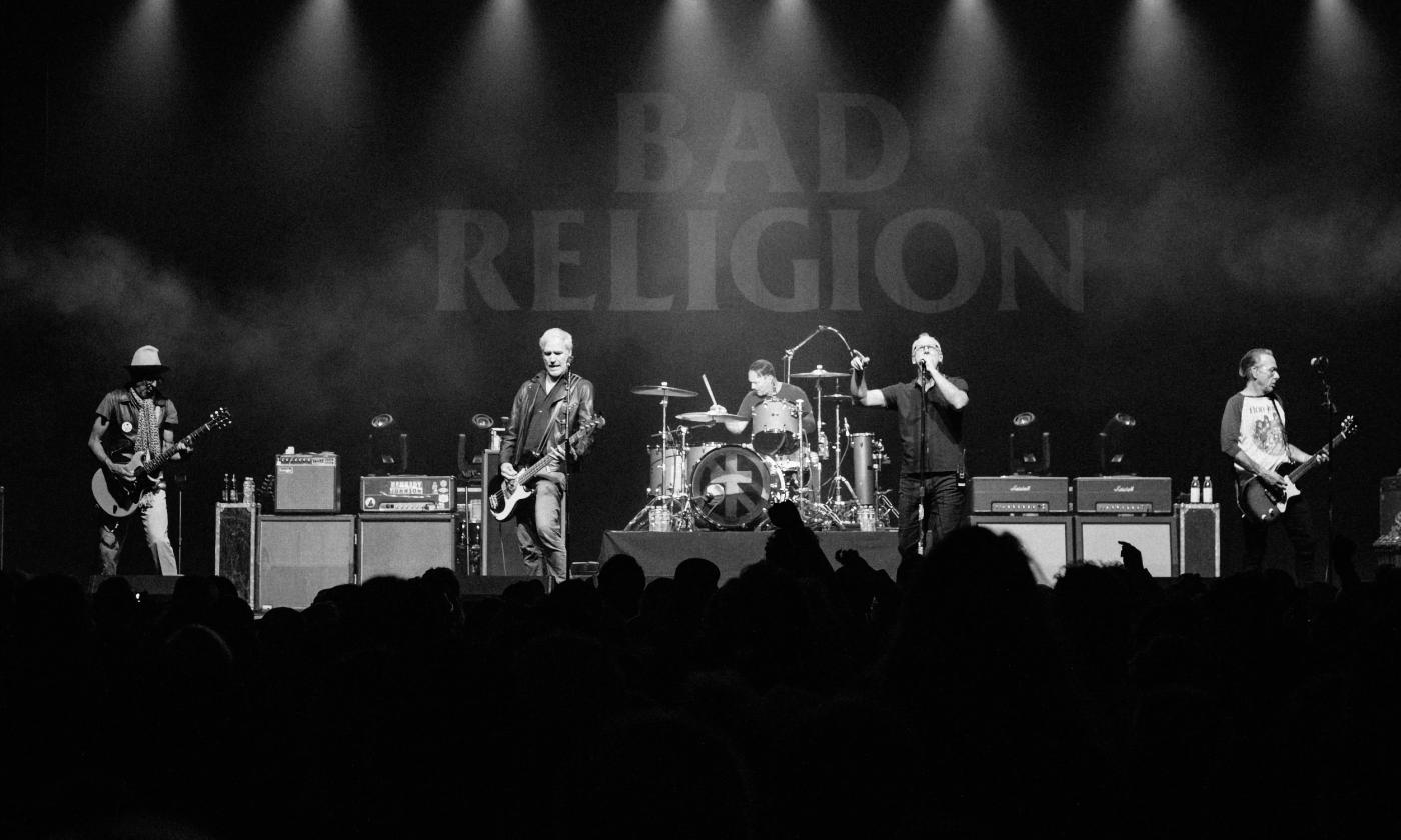 The five members of Bad Religion, performing on stage and seen in black and white