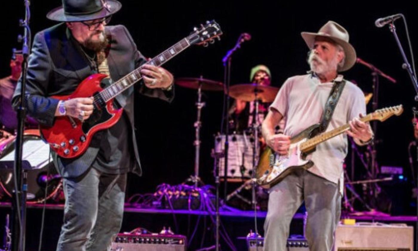 Bandmembers from Jimmy Vivino perform live on stage with their guitars. 