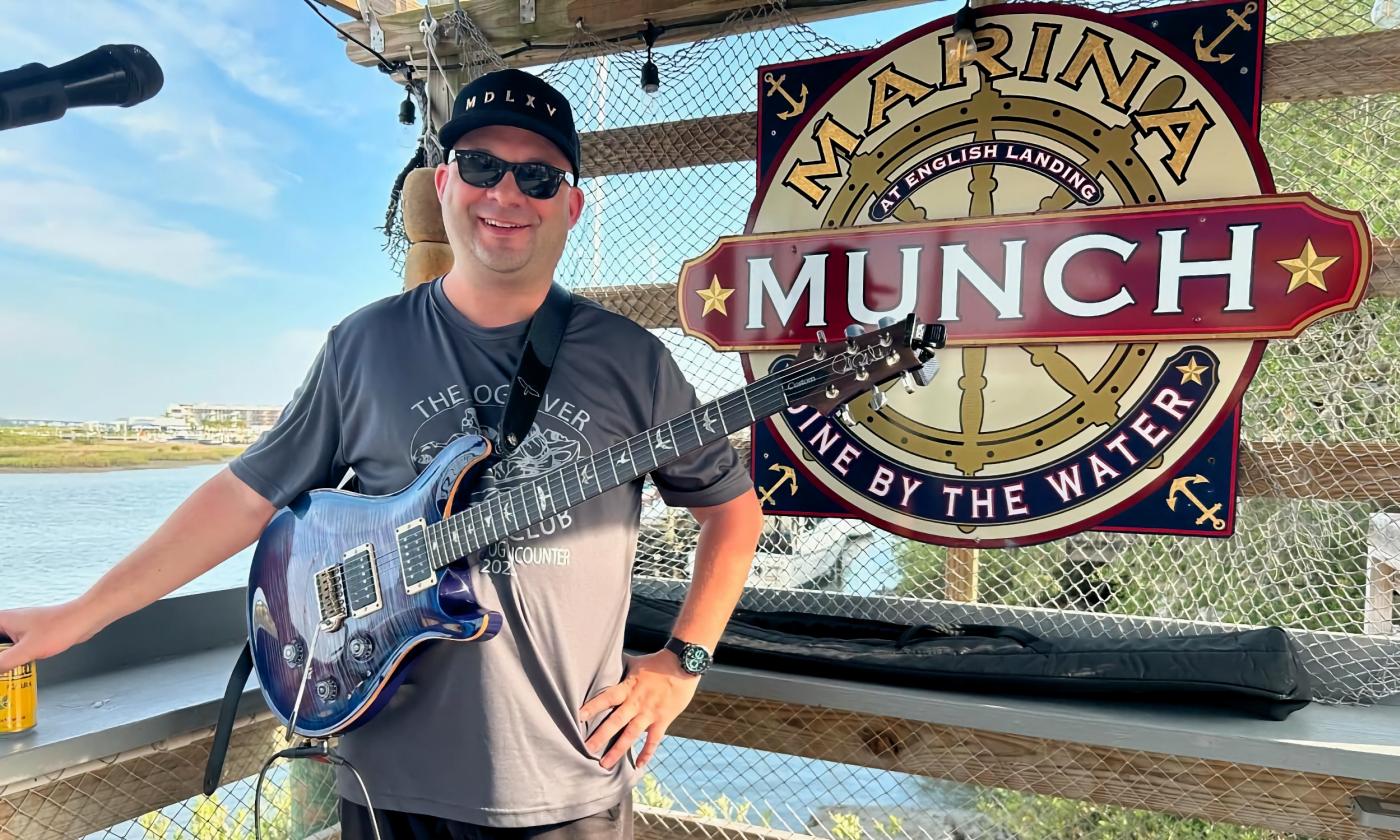 Ollie Twist standing in front of the Marina Munch sign