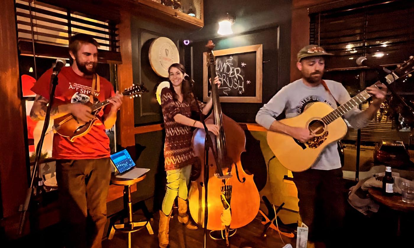 Three musicians play their Bluesgrass instruments at Stogies Cigar Lounge.