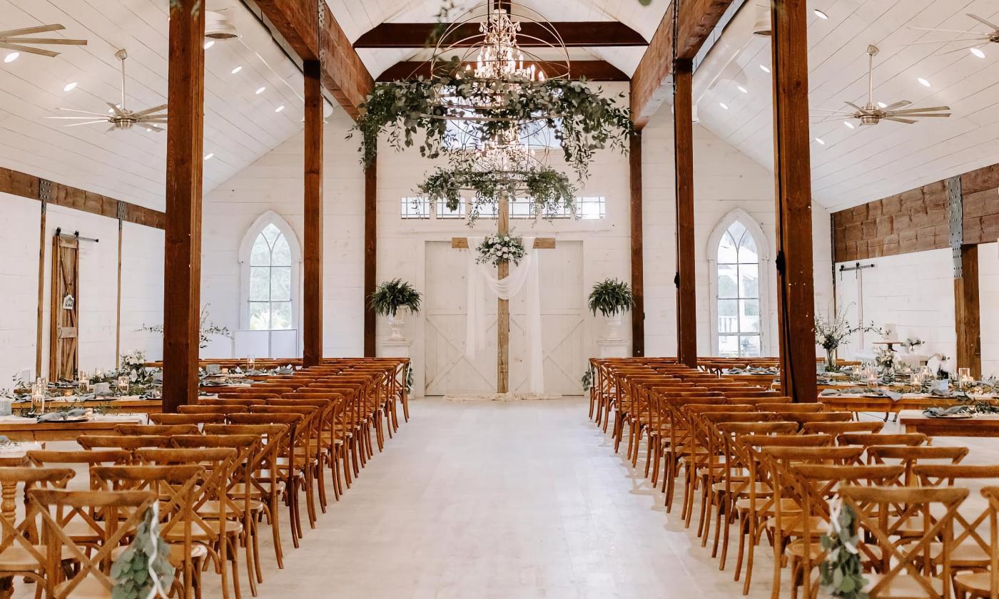 A wedding ceremony with greenery accents in the light fixtures