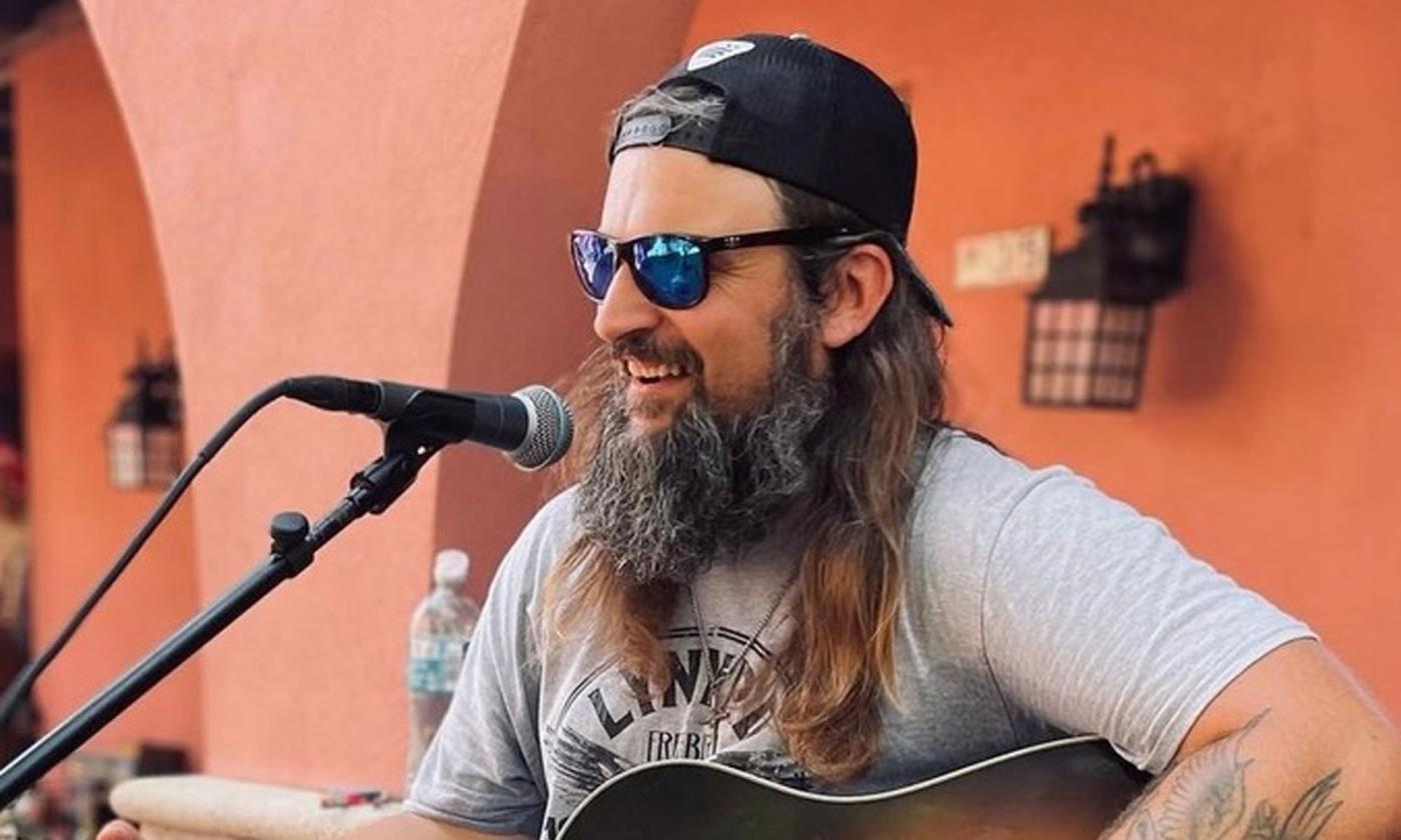 Musician Josh "Tennessee" Worthe with his guitar, singing